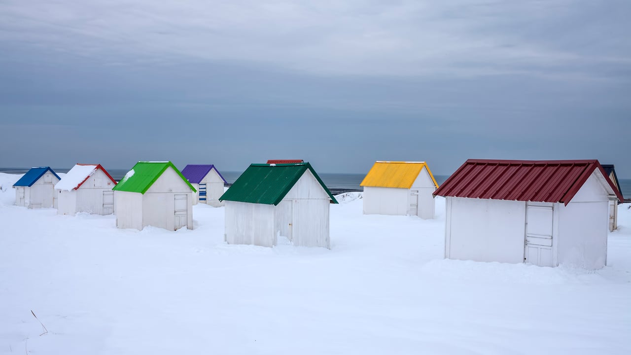 Cabanes aux toits colorés recouvertes de neige à Gouville-sur-Mer, Normandie (© Andia/Getty Images) desktop wallpaper