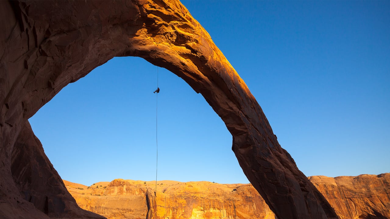 A man rappels off Corona Arch near Moab, Utah (© Grant Ordelheide/TANDEM Stills + Motion) desktop wallpaper