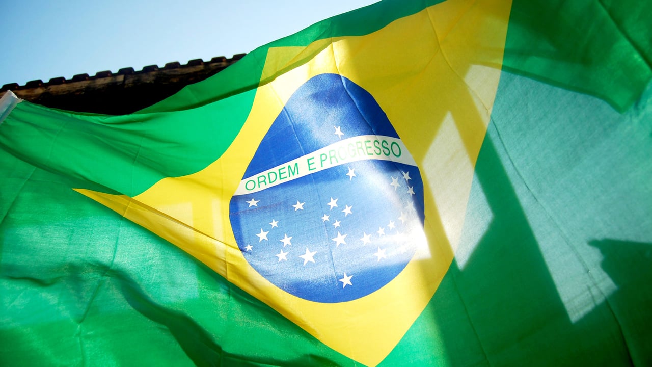 Bandeira brasileira voando sob o céu azul (© GideoniJunior/Getty Images) desktop wallpaper