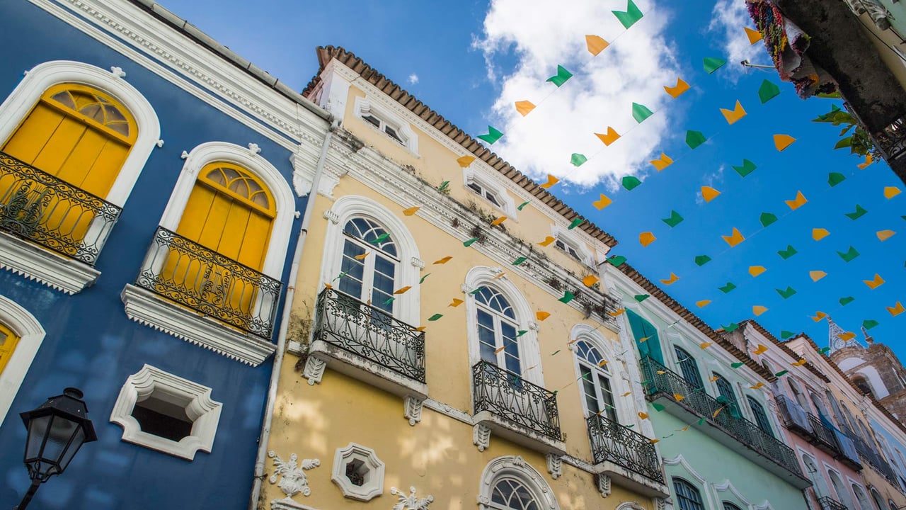 Rua em Salvador decorada com bandeiras coloridas entre prédios (© Henn Photography/Aurora Photos/Getty Images) desktop wallpaper