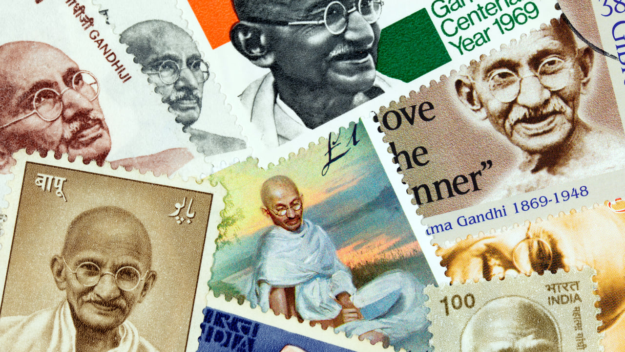 An assortment of postage stamps with images of Mahatma Gandhi (© PictureLake/E+/Getty Images) desktop wallpaper