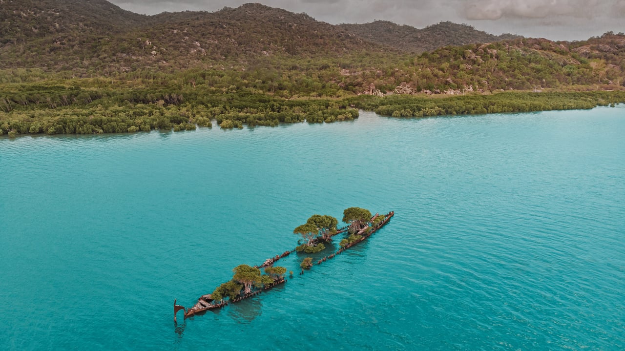Aerial view of the City of Adelaide shipwreck with trees growing on it, Magnetic Island, Queensland, Australia (© Amazing Aerial Agency/Offset by Shutterstock) desktop wallpaper