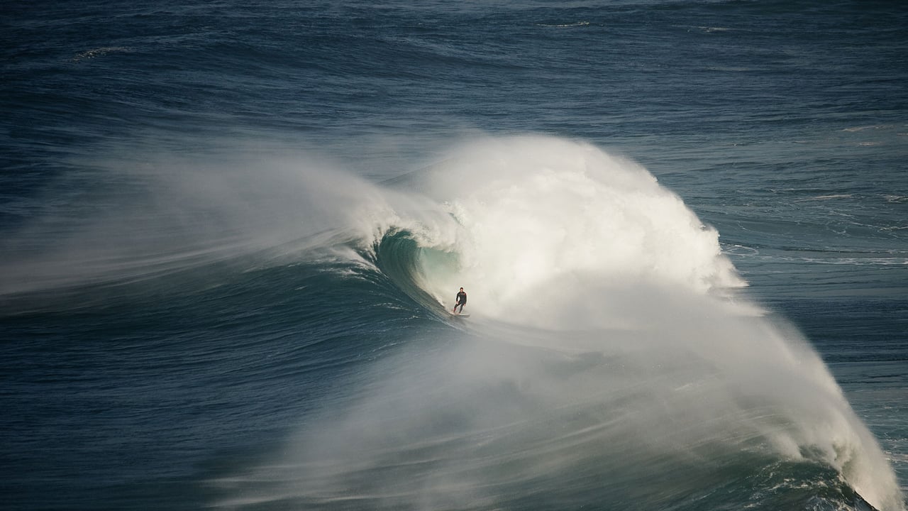 Surfer riding a wave in Nazaré, Portugal (© Rui Caria/Getty Images) desktop wallpaper