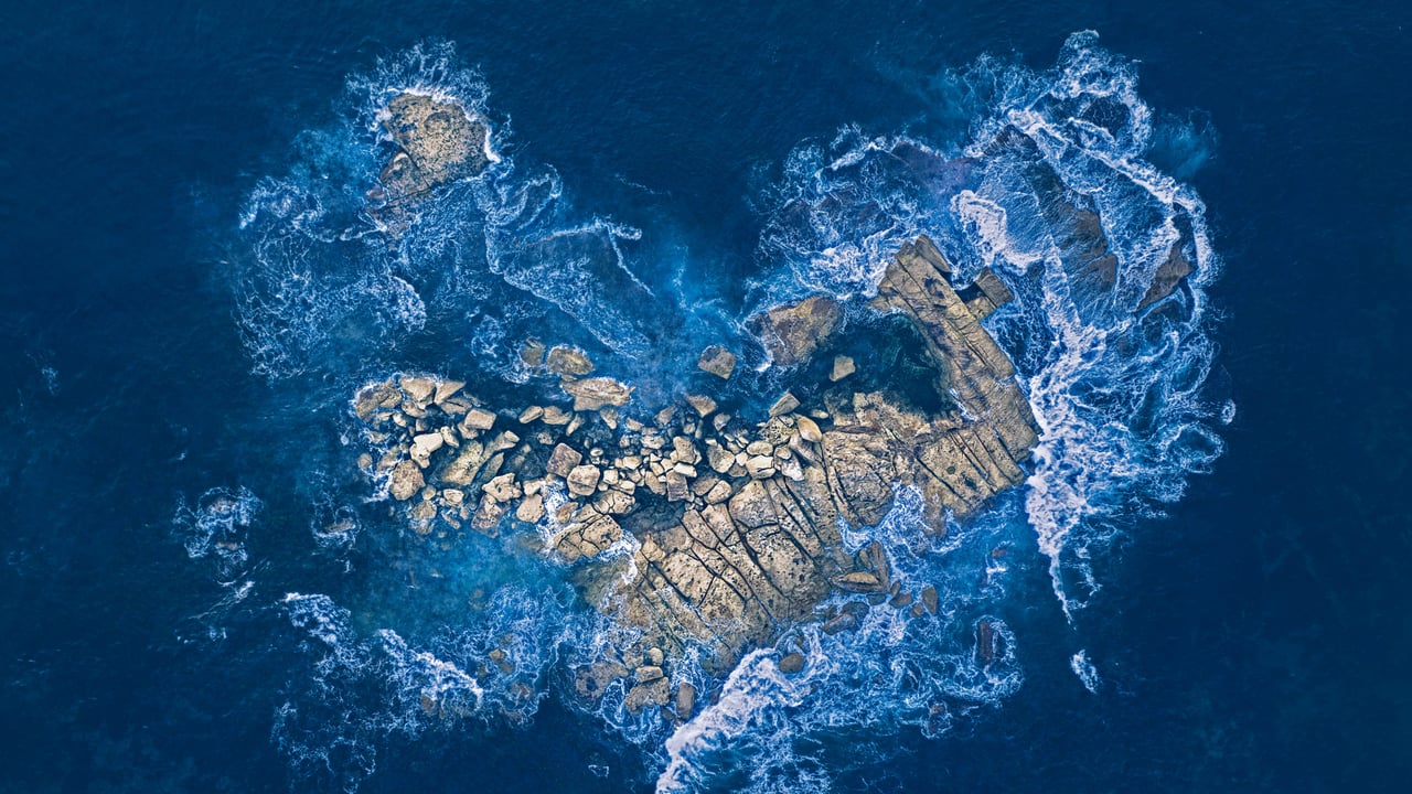 Ocean waves crashing over a heart-shaped rock island off the coast of Sydney, Australia (© Kristian Bell/Getty Images) desktop wallpaper