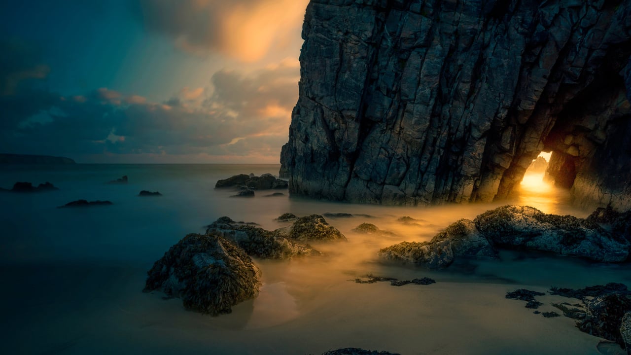 Light from sunrise through a sea cave on the Isle of Skye, Scotland (© Luca Benini/PLM Collection/Offset) desktop wallpaper