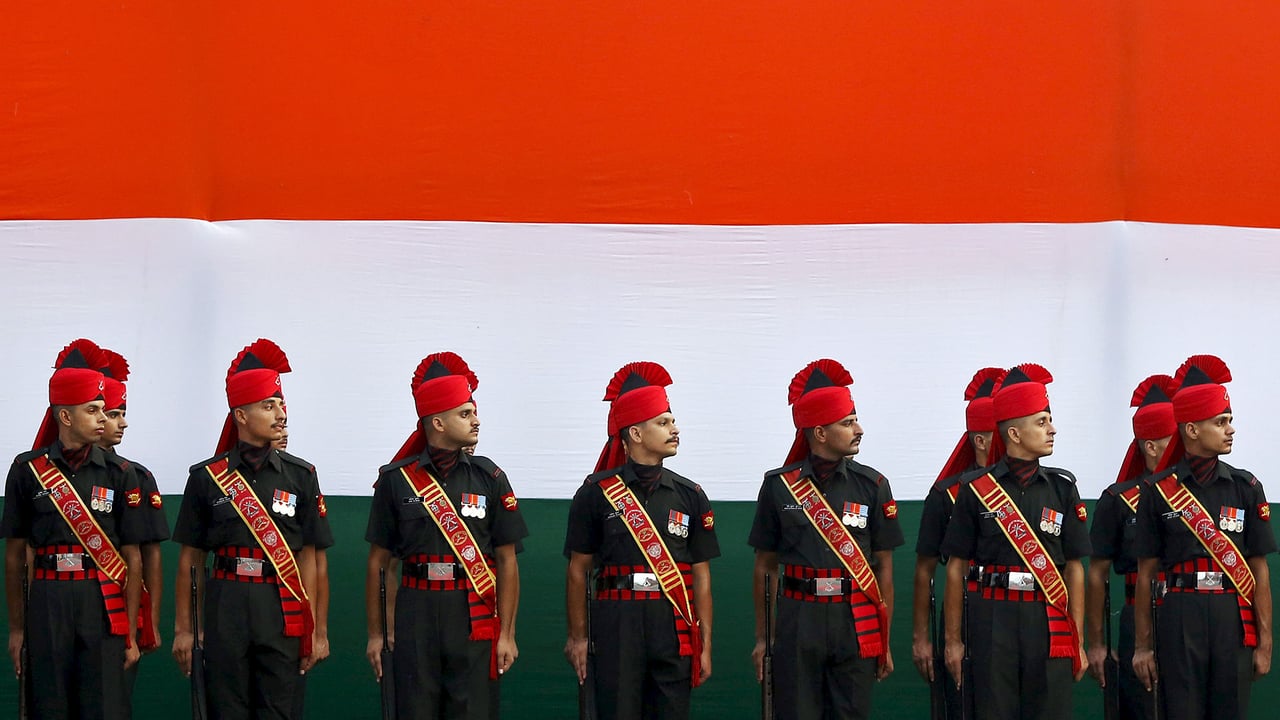 Soldiers stand guard in front of a tricolour flag rehearsal (© Adnan Abidi/Reuters) desktop wallpaper