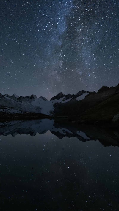 Stars reflected in the Totensee, a mountain lake at Grimsel Pass, Switzerland (© magodevita/Getty Images) mobile wallpaper