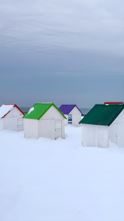 Cabanes aux toits colorés recouvertes de neige à Gouville-sur-Mer, Normandie (© Andia/Getty Images) mobile wallpaper