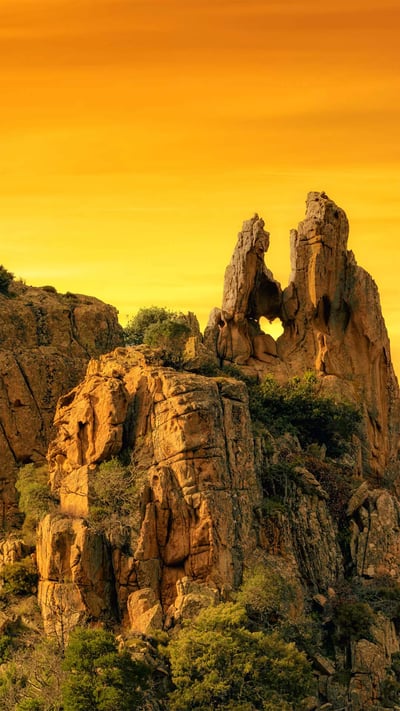 A heart-shaped hole in the rock formation of Calanques de Piana in Corsica, France (© joningall/Getty Images) mobile wallpaper