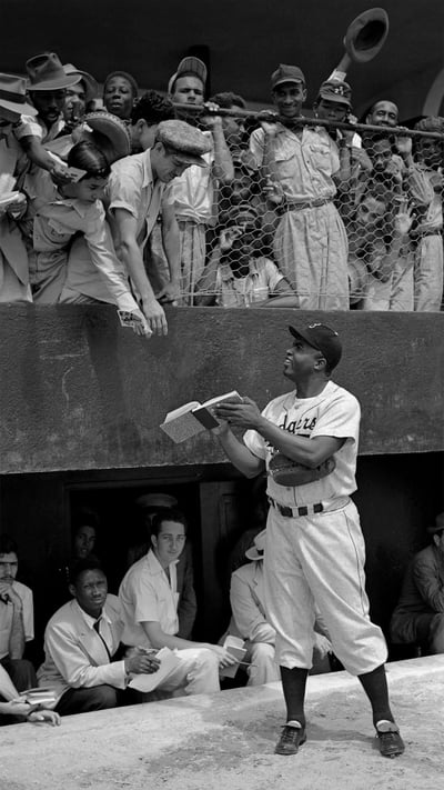 Jackie Robinson signs autographs at spring training in Ciudad Trujillo, now Santo Domingo, Dominican Republic, on March 6, 1948 (© Bettmann/Getty Images) mobile wallpaper