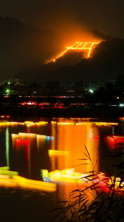 「五山送り火の鳥居形松明と灯篭流し」京都 (© Kaoru Hayashi/Getty Images) mobile wallpaper