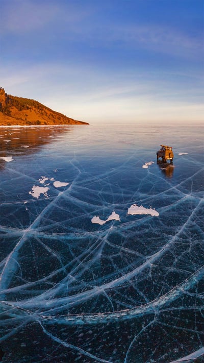 Aerial view of a car crossing over the frozen surface of Lake Baikal, Russia (© Amazing Aerial Agency/Offset) mobile wallpaper