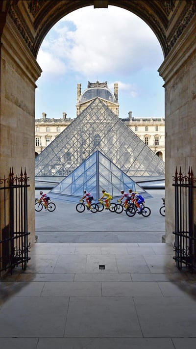Tour de France riders in front of the Louvre Pyramid and Museum in Paris, France, during the 2020 race (© Martin Bureau/AFP via Getty Images) mobile wallpaper