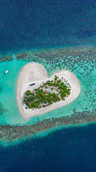 Heart-shaped island with sandy beach, offshore coral reef, Indian Ocean, Maldives (© Willyam Bradberry/Shutterstock) mobile wallpaper