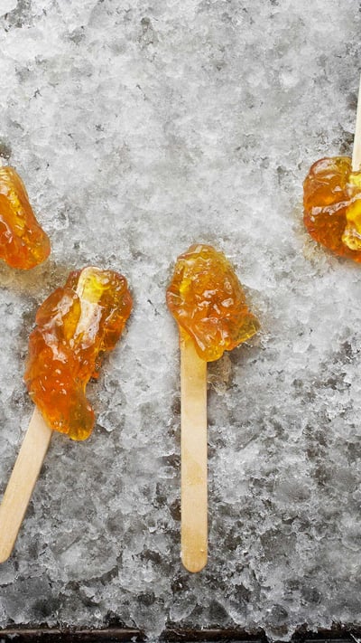 Hardened maple syrup on a wooden stick sitting on ice, Elmira, Ontario (© Design Pics/Offset/Shutterstock) mobile wallpaper