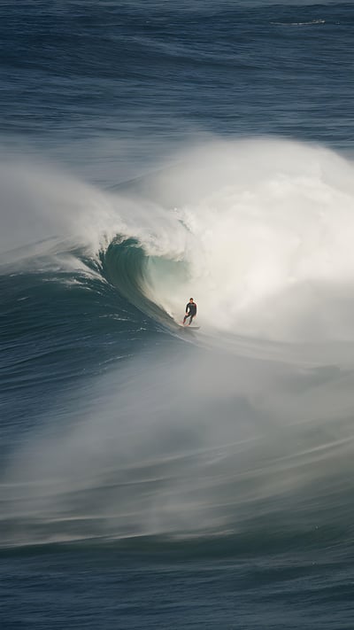Surfer riding a wave in Nazaré, Portugal (© Rui Caria/Getty Images) mobile wallpaper