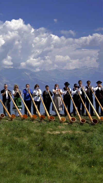 Alphorn musicians perform during the International Alphorn Festival in Nendaz, Switzerland (© Fabrice Coffrini/Getty Images) mobile wallpaper