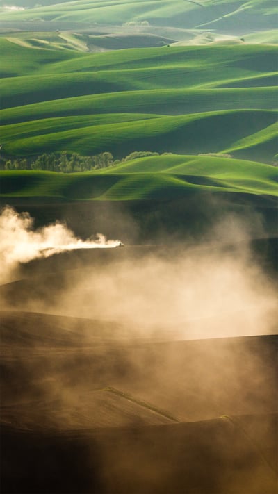 A tractor kicks up dust while tilling fields on the Palouse near Pullman, Washington (© Ben Herndon/Tandem Stills + Motion) mobile wallpaper