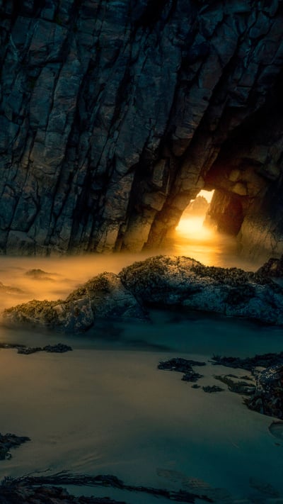 Light from sunrise through a sea cave on the Isle of Skye, Scotland (© Luca Benini/PLM Collection/Offset) mobile wallpaper